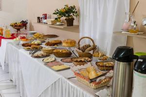 a table filled with different types of bread and pastries at Itaporanga Pousada in Santa Maria Madalena +27 photos