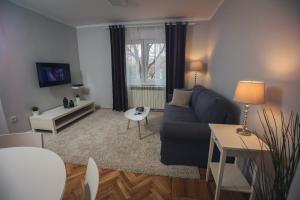 un soggiorno con divano blu e tavolo di Green Avenue Apartment Zagreb a Zagabria