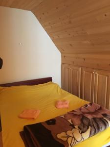 a bedroom with a bed with a yellow comforter at Villa Aleksandar in Kopaonik