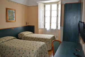 a bedroom with two beds and a window at Albergo Italia in Varallo +17 photos