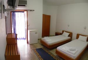 a small room with two beds and a window at Samaria in Agia Roumeli