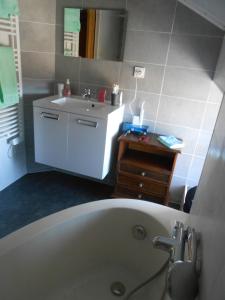 a bathroom with a white tub and a sink at Gîte Puy Morin in Montournais +5 photos