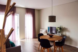 een woonkamer met een tafel met stoelen en een computer bij Apartamento da Lapa in Porto