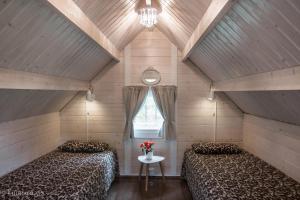 Cette chambre mansardée comprend 2 lits et une fenêtre. dans l'établissement Glamping & Camping, à Îles Vestmann