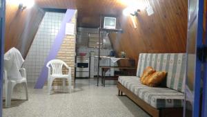 a living room with a couch and a kitchen at Condomínio Sol Mar e Cia in Boicucanga