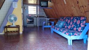 a living room with a couch and a fan at Condomínio Sol Mar e Cia in Boicucanga