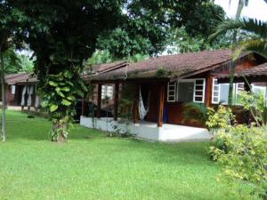 ein kleines Haus mit einem grünen Hof davor in der Unterkunft Casa Condomínio Boiçucanga in Boicucanga