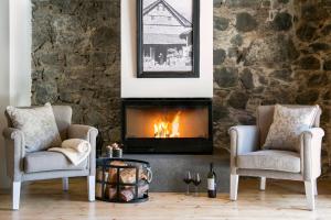 a living room with two chairs and a fireplace at Casale Panayiotis in Kalopanayiotis