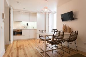 a kitchen and dining room with a table and chairs at Chiado Cozy Apartments - by LU Holidays in Lisbon