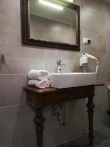 un lavandino in bagno con specchio e asciugamani di Apartament Akademicka a Zamość