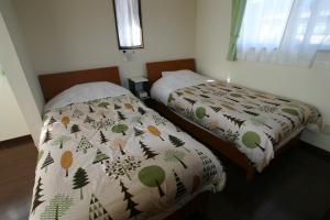 富士河口湖町にあるヴィラ  メイクイーンのベッドルーム1室(隣り合わせのベッド2台付)