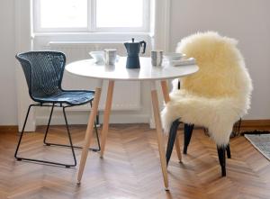 a white table with two chairs and a table with a furry seat at Design apartment Degengasse in Vienna
