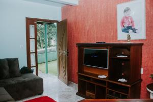 un soggiorno con divano e TV di Casa de Férias Kaspary a Gramado