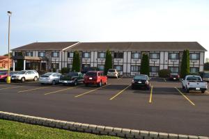 a parking lot with cars parked in front of a building at Sky Lodge Inn & Suites - Delavan in Delavan