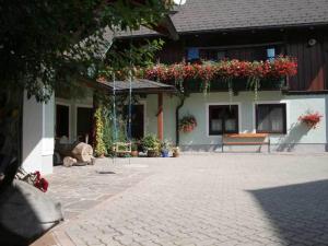 einen Innenhof mit einem Gebäude mit einer Bank und Blumen in der Unterkunft Kanzlerhof in Bad Mitterndorf