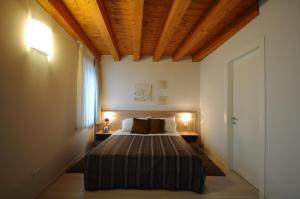 a bedroom with a bed in a room with wooden ceilings at Albergo Leon Bianco Gonars in Gonàrs