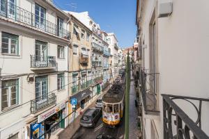 a tram on a city street with buildings at Chiado Cozy Apartments - by LU Holidays in Lisbon