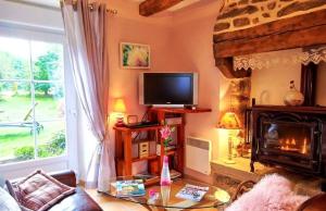 sala de estar con chimenea y TV en gites de rêve en Finistère en Quéménéven