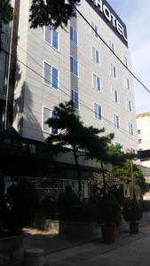 a hotel building with a tree in front of it at New Grand Hotel in Daegu