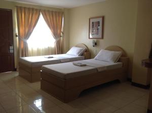 塔克洛班的住宿－丹內爾潘系娜內酒店，酒店客房设有两张床和窗户。