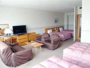 a hotel room with two beds and a living room at Tsumagoi Resort Sai no Sato in Kakegawa