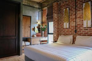 una camera da letto con un muro di mattoni e un letto di Goodhope Villa a Sam Roi Yot Altre 80 foto