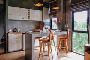 a kitchen with a large counter with stools in it at Goodhope Villa in Sam Roi Yot