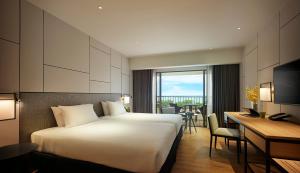 a hotel room with a bed and a desk at PARKROYAL Penang Resort in Batu Ferringhi