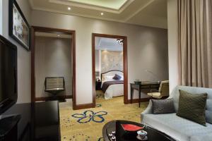 uma sala de estar com um sofá e uma cama em Ramada Plaza Tianlu Hotel em Wuhan