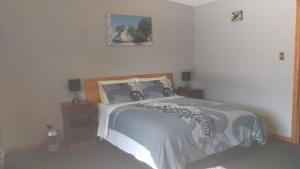 a bedroom with a bed and two night stands with lamps at Koutu Beach Bed and Breakfast in Rotorua
