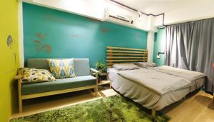 a bedroom with a bed and a couch and a chair at Leo Ho Hostel in Tainan