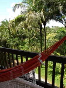 a hammock on a balcony with palm trees at Paraíso das Águas Hotel Bahia in Ituberá