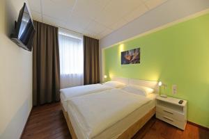 um quarto com uma cama branca e uma televisão em Business & City em Linz
