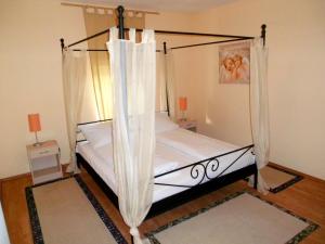 a bedroom with a canopy bed with white curtains at HAHNE Hotel und Appartements in Hannover