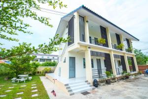 une maison blanche avec des escaliers et une cour dans l'établissement Sweet Dreams, à Phetchaburi