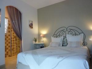 ein Schlafzimmer mit einem großen weißen Bett mit weißen Kissen in der Unterkunft L Olivadou B&B in Trans-en-Provence