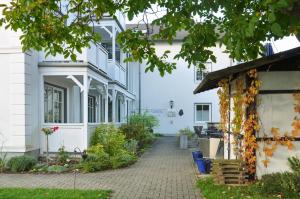 ein weißes Gebäude mit einem Gehweg davor in der Unterkunft Haus Svantekahs in Glowe