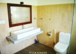 uma casa de banho com um lavatório, um WC e um espelho. em Villa Dineha em Hikkaduwa