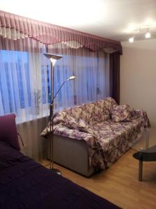 a living room with a couch in front of a window at Astra City Centre Apartment in Tallinn