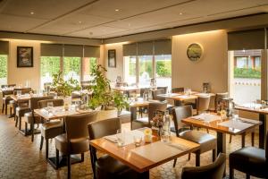 un ristorante con tavoli, sedie e finestre di Campanile Hotel & Restaurant Gent a Gand