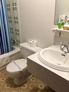 Villagers Inn في Fruitvale: حمام ابيض مع مرحاض ومغسلة