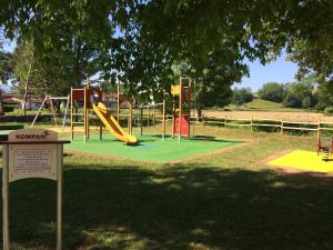 a playground with a slide in a park at Camping Pyrénées Nature in Oloron-Sainte-Marie