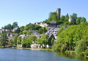 a town on a hill next to a river at Pension Antik in Bad Lobenstein