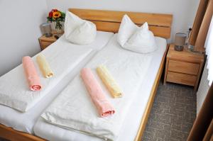 2 Betten mit weißer Bettwäsche und rosa Kissen darauf in der Unterkunft Hotel Atlantik in Borkum