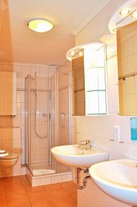 a bathroom with a sink and a shower and a toilet at Hotel Atlantik in Borkum