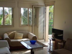 a living room with a couch and a tv at Byreva Apartments in Paphos