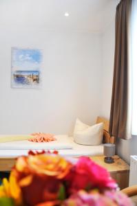 a room with a bed and a table with flowers at Hotel Atlantik in Borkum