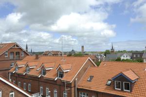 een groep bakstenen gebouwen met oranje daken bij Hotel Atlantik in Borkum