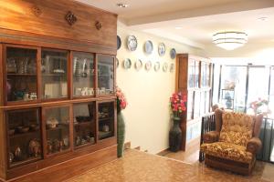 a living room with a glass cabinet and a chair at B&B hostel @ Jomtien in Jomtien Beach