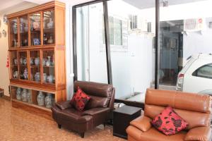 a living room with two chairs and a cabinet at B&B hostel @ Jomtien in Jomtien Beach
